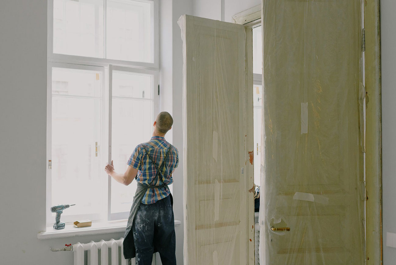 A person installing a window frame assembly made of eco-friendly materials.
