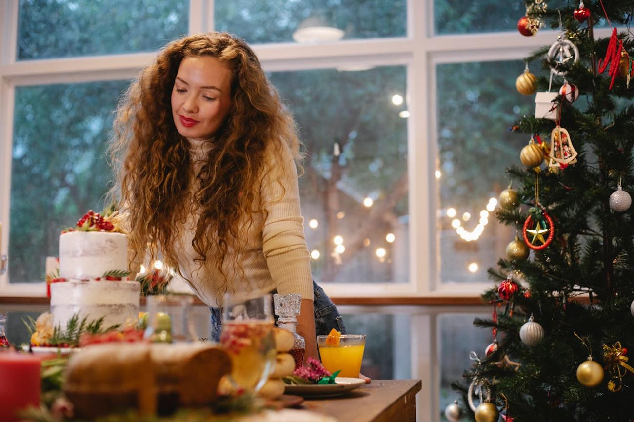 Woman preparing holiday dinner in front of large windows