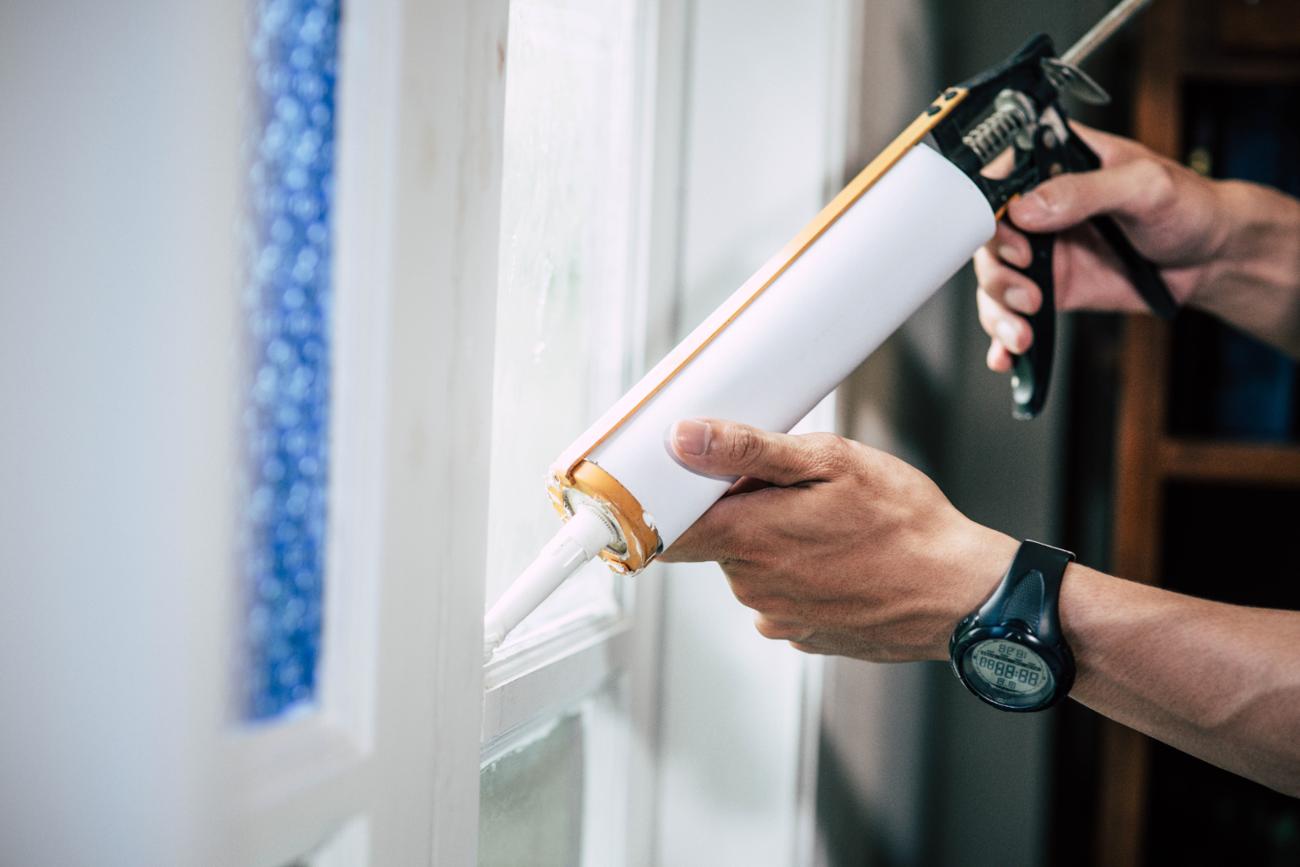 Man caulking window