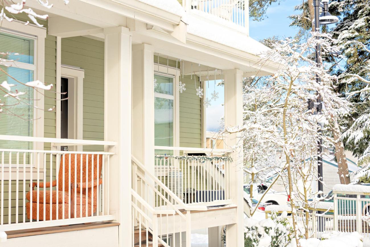 Porch and windows of a house covered in winter snow