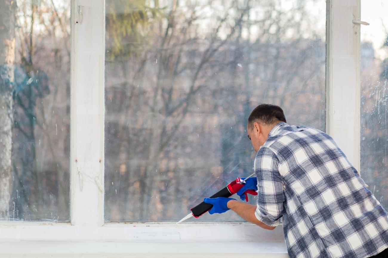 Man caulking a window