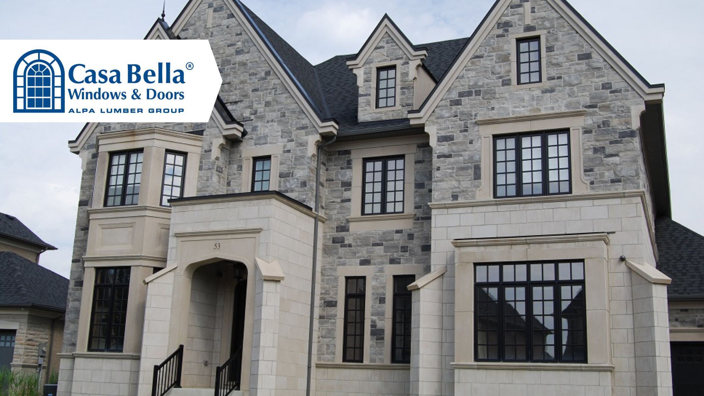 Elegant stone house featuring black-framed energy-efficient windows by Casa Bella Windows & Doors.