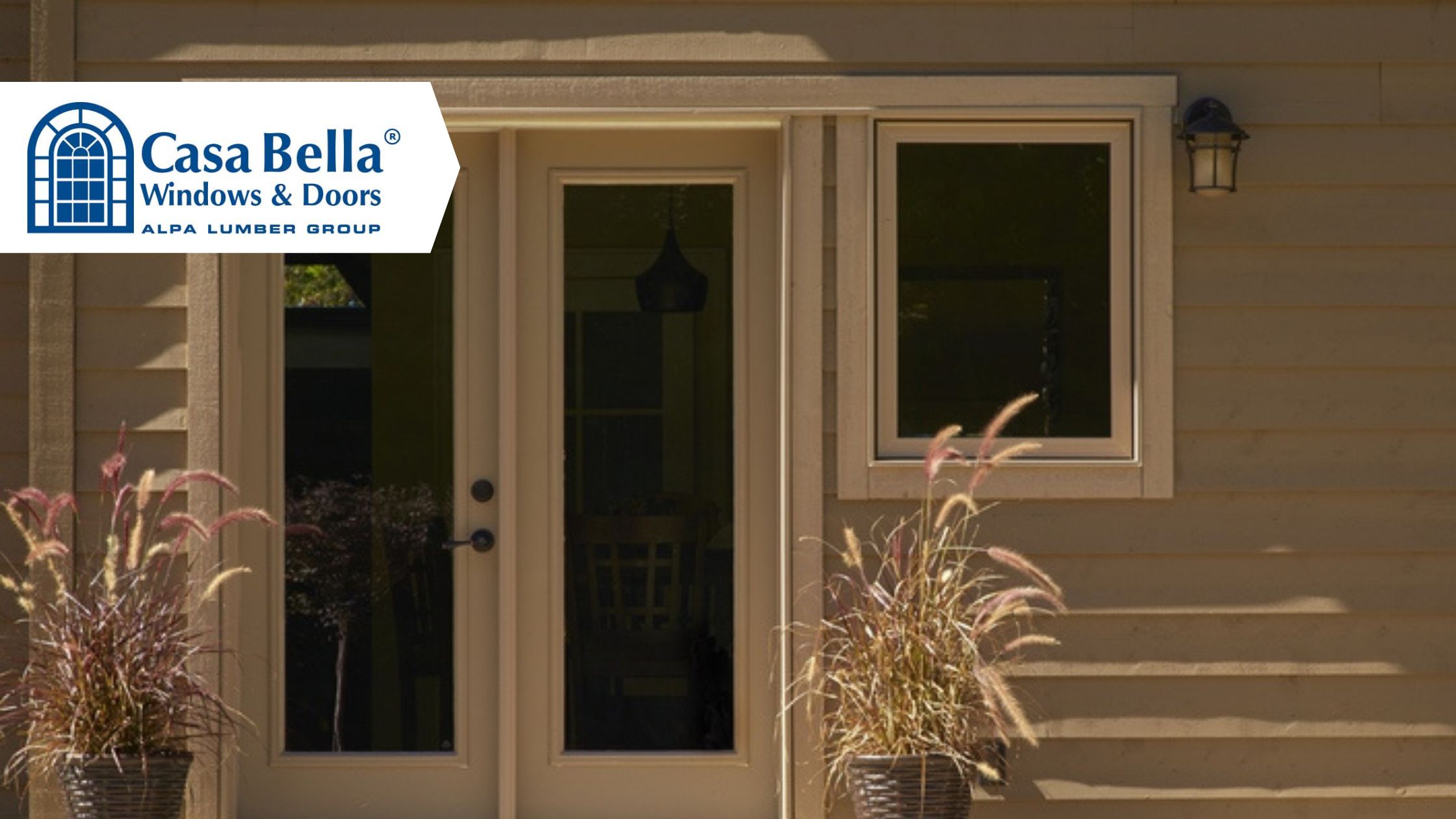 Casa Bella patio door and window installation on a residential home exterior with beige siding and decorative plants beside the entrance