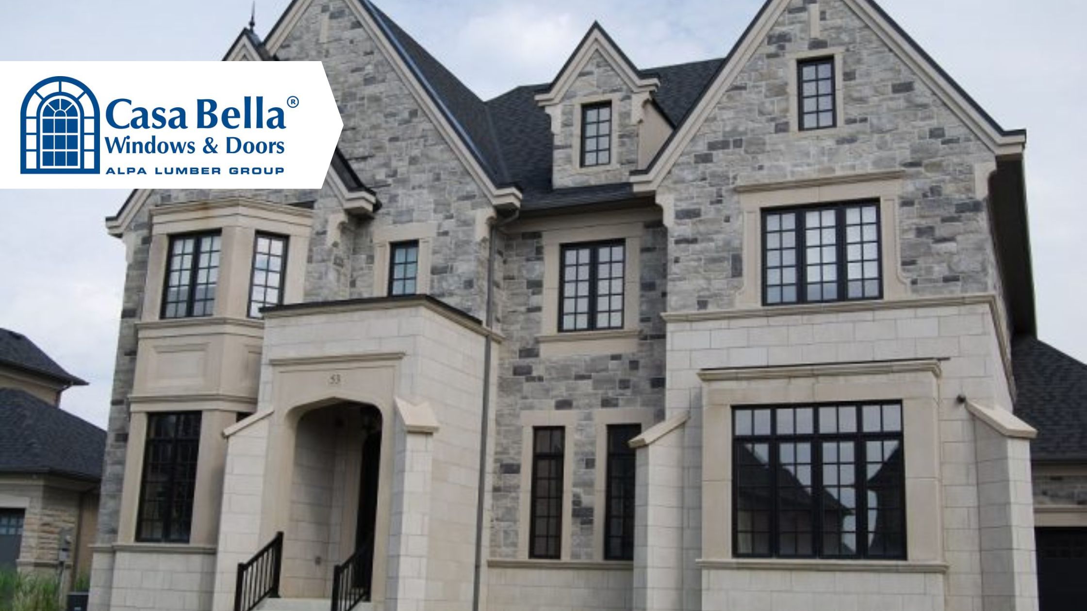 Casa Bella Windows & Doors installed on a luxury stone home featuring large black-framed windows